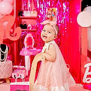 Bianca is registered to the contest to win money with this photo: toddler, child, pink, dress, headband, toy, push_toy, balloons, barbie, shopping_bag, smile, happy, indoor, decoration, party, shiny, curtain, accessories, footwear, play