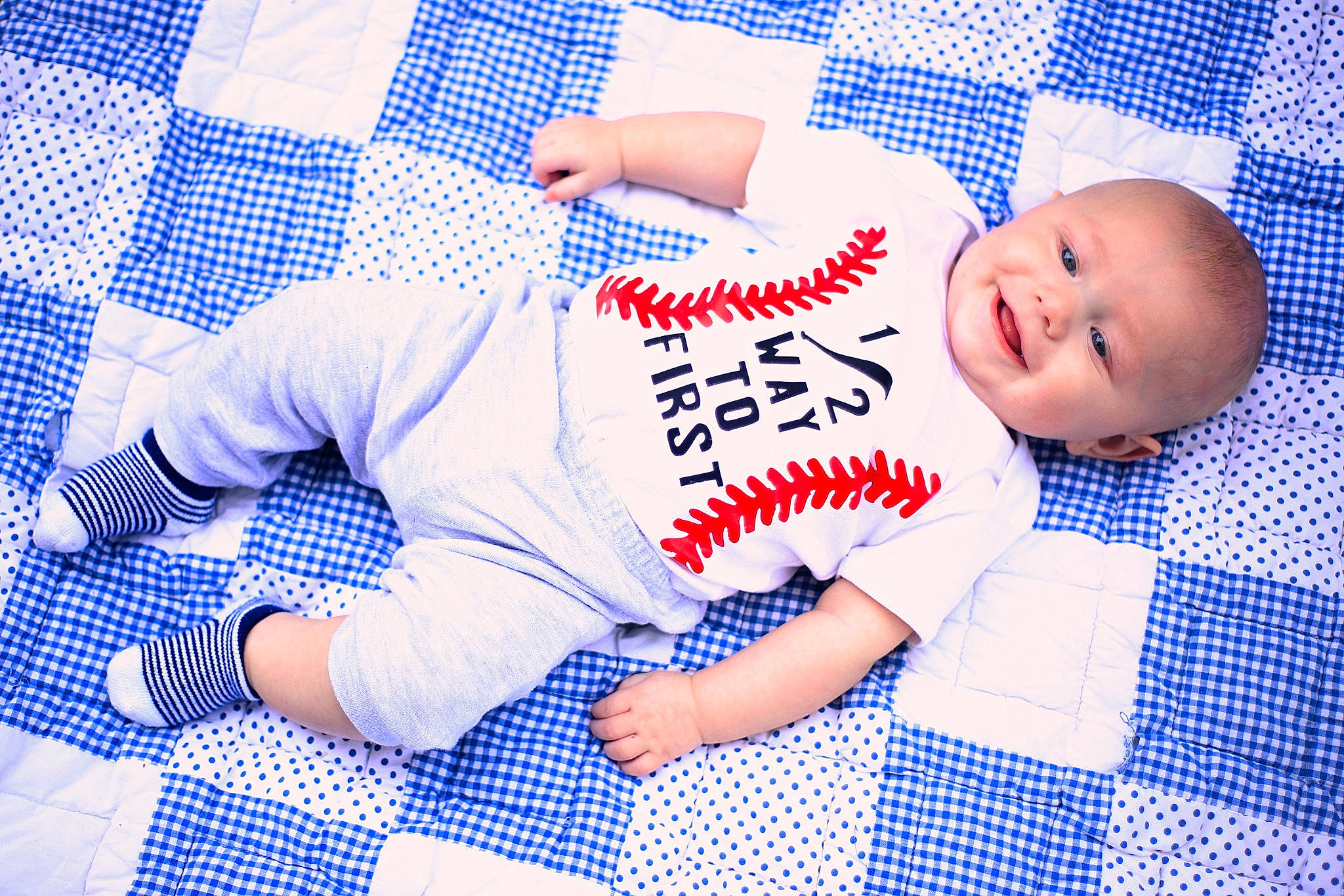 Oakley is registered to the contest to win money with this photo: arm, baby, baby_safety, baby_toddler_clothing, blue, comfort, elbow, electric_blue, flooring, font, fun, knee, linens, pattern, person, sleeve, sportswear, t_shirt, textile, thigh