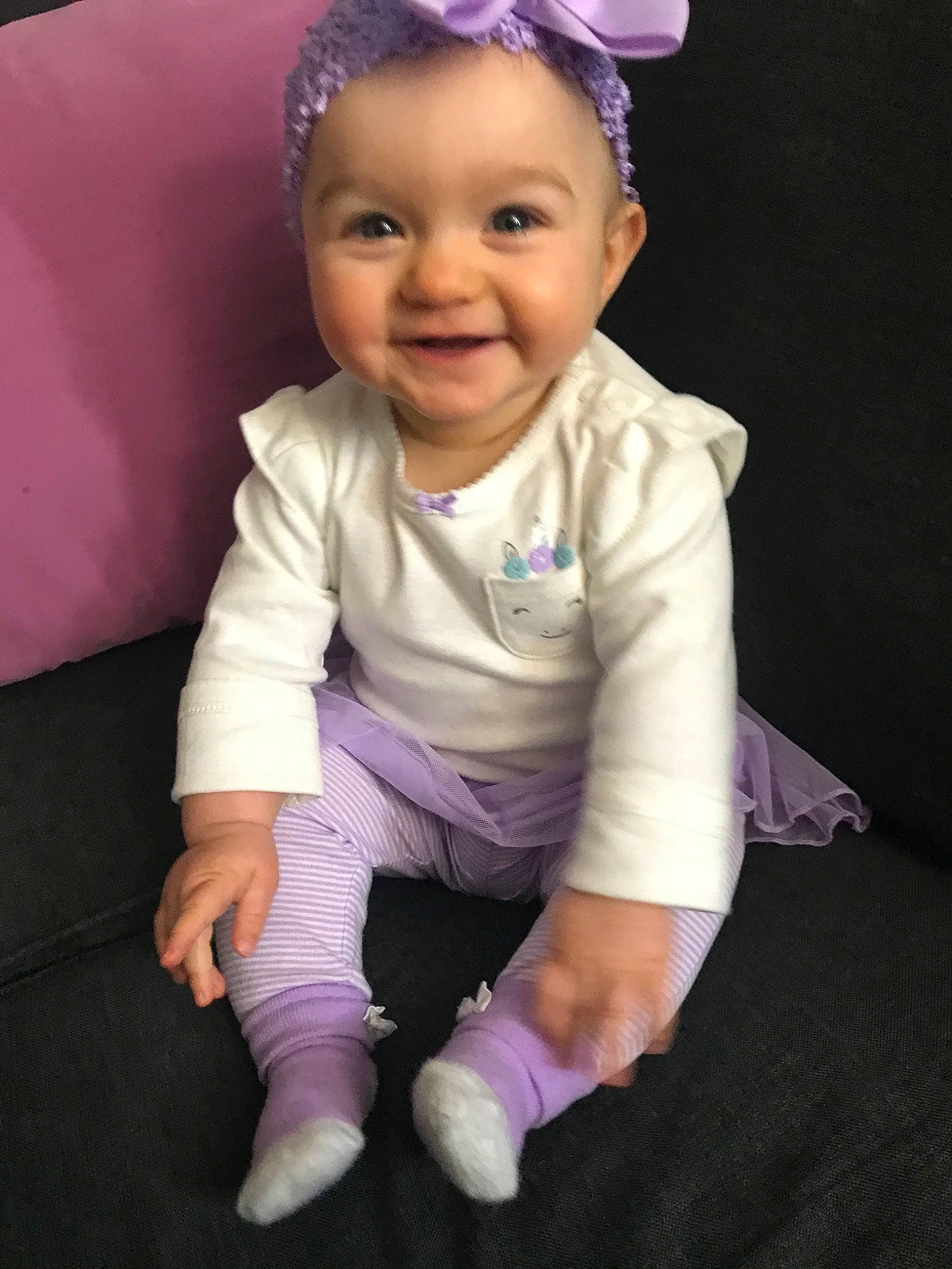 Devyn is registered to the contest to win money with this photo: baby, baby_products, baby_toddler_clothing, cheek, child, child_model, hair_accessory, head, headgear, joy, person, pink, product, purple, sitting, skin, smile, toddler