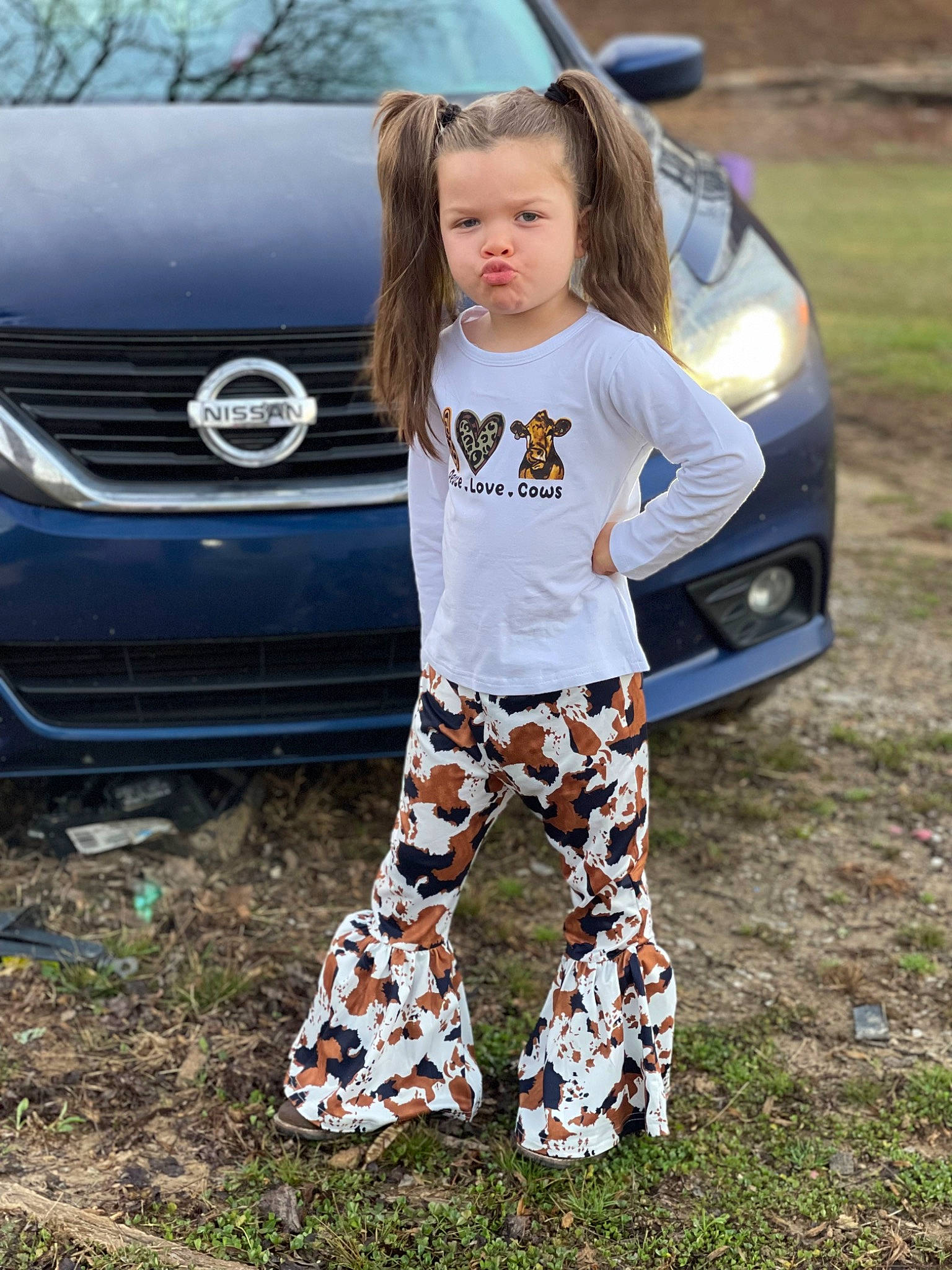 Aubree is registered to the contest to win money with this photo: automotive_design, automotive_exterior, automotive_lighting, automotive_tire, bumper, car, grass, grille, hood, land_vehicle, leg, mammal, motor_vehicle, person, personal_luxury_car, sportswear, tire, vehicle, vehicle_door, vertebrate