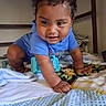 toddler, child, baby, crawling, blue_shirt, bed, blanket, pillow, indoor, curly_hair, smiling, happy, cute, person, home, young_child, playful, skin, furniture, portrait