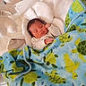baby, newborn, sleeping, blanket, turtle_pattern, blue_blanket, white_cushion, bunny_ears, soft_texture, infant, cozy, resting, child, cute, indoor, bed, sleep, peaceful, person, warm