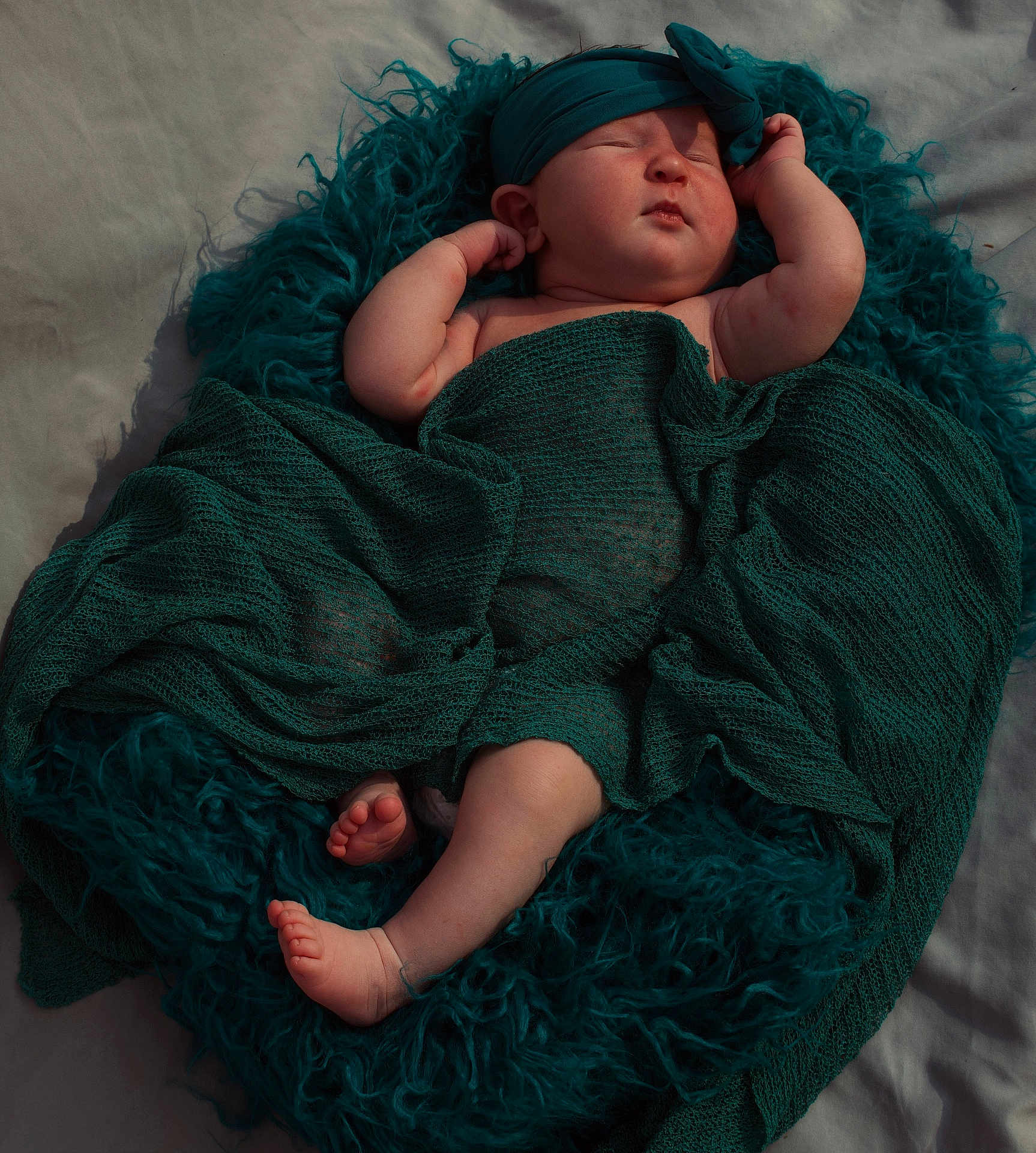 Ella joined the competition — help win amazing prizes! baby, sleeping, blanket, headband, cushion, teal, infant, newborn, soft_texture, wrapped, peaceful, resting, cozy, cute, skin, feet, hand, portrait, indoors, fabric