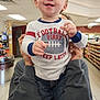 toddler, child, smiling, shirt, football, indoor, store, aisle, sneakers, adult, holding, happy, clothing, person, retail, shelf, casual, jeans, portrait, face