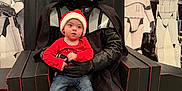 Skyler joined the competition — help win amazing prizes! black_cloak, bucket, candy_cane, chair, child, costume, darth_vader, event, holiday, indoor, jeans, person, portrait, red_shirt, santa_hat, star_wars, stormtrooper, toddler, toy, white_shoes