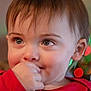 baby, background_blur, bokeh, child, closeup, cute, expression, eyes, face, festive_lights, hair, hand, indoor, person, portrait, red_clothing, sitting, skin, toddler, young