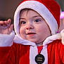 Skyler is registered to the contest to win money with this photo: baby, celebration, child, christmas, costume, cute, cute_outfit, face, festive, happy, holiday, indoor, person, portrait, red_clothing, santa_hat, seasonal, smiling, toddler, warm