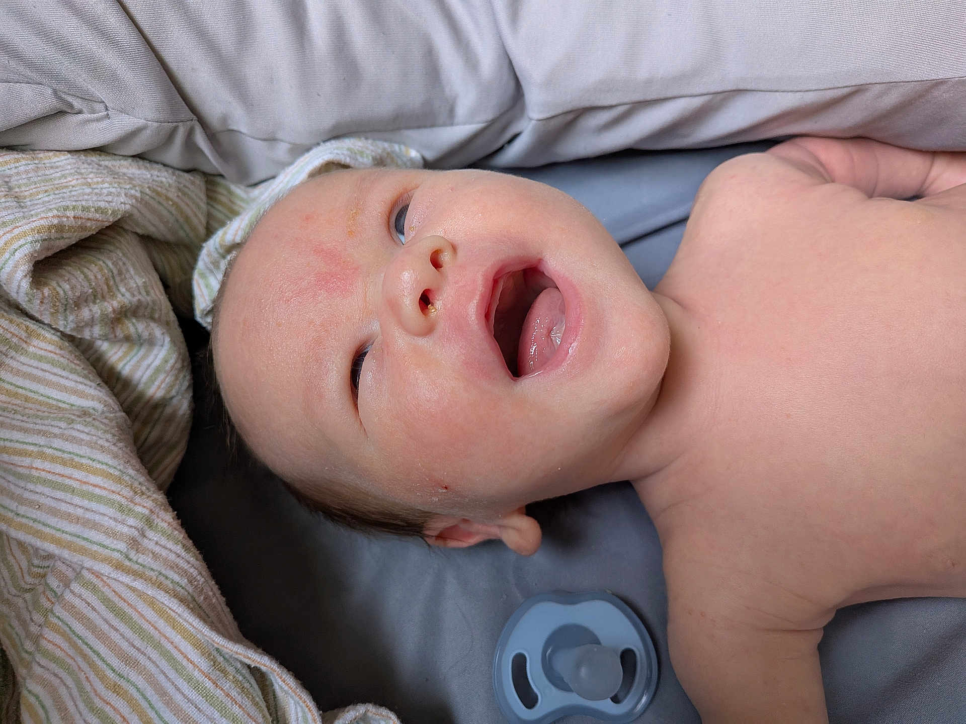 Charlie joined the competition — help win amazing prizes! baby, infant, face, mouth_open, lying_down, blanket, pacifier, skin, head, expression, cute, newborn, sleeping_area, soft_texture, child, portrait, indoors, closeup, resting, comfort