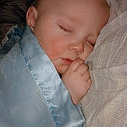 Christopher is registered to the contest to win money with this photo: baby, sleeping, blanket, blue_blanket, pillow, face, hand, cozy, indoors, child, peaceful, resting, soft, closeup, young_child, person, nap, toddler, cute, comfort