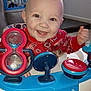 Christopher joined the competition — help win amazing prizes! baby, smiling, teeth, toy, activity_center, walker, safety_logo, blue, red, plastic_toy, indoor, hardwood_floor, window, laundry_basket, crib_gate, blond_hair, hair_tuft, happy, closeup, portrait