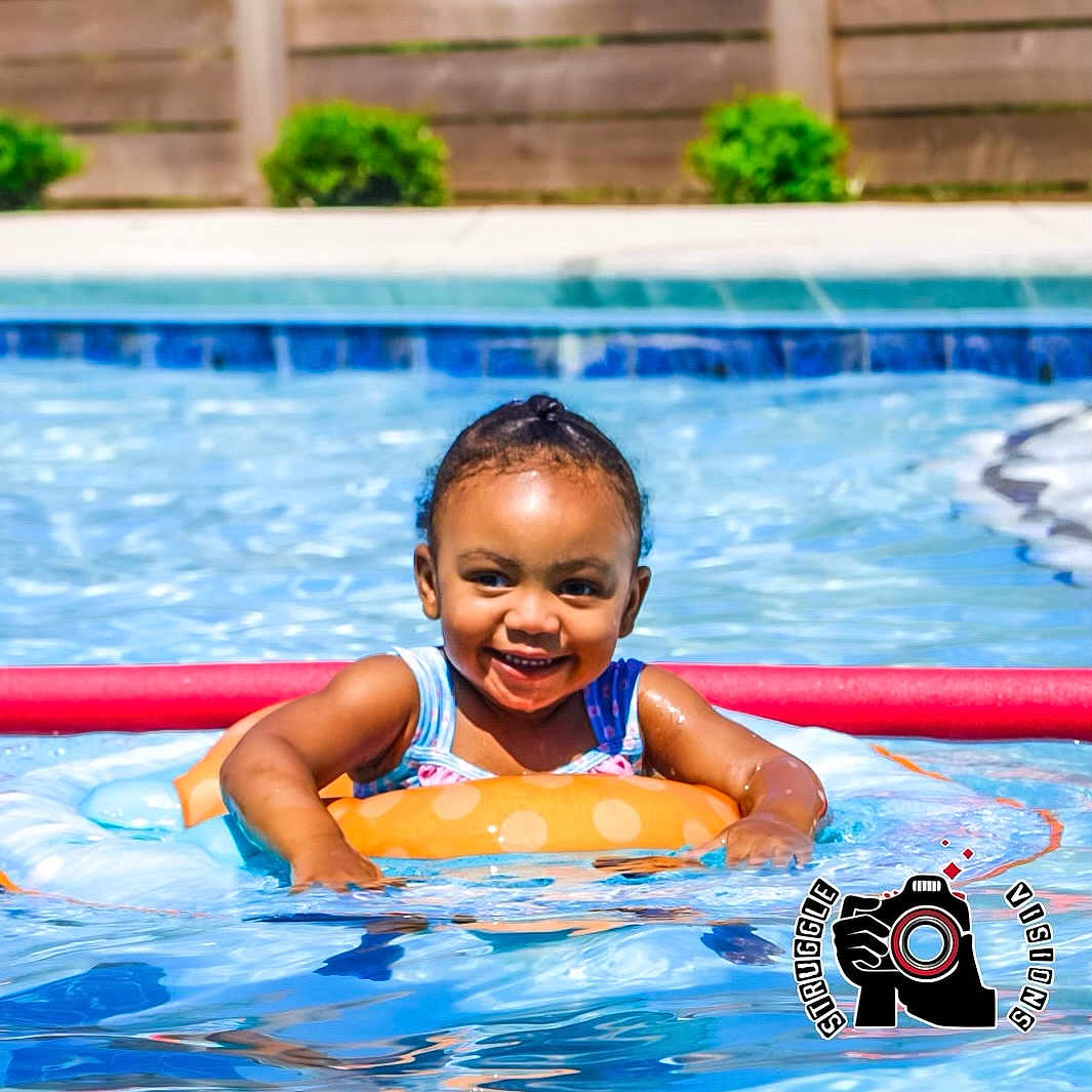 Kali is registered to the contest to win money with this photo: baby, clothing, face, happy, head, laughing, leisureactivities, lifejacket, person, photography, pool, portrait, sport, summer, swimming, swimmingpool, swimwear, vest, water, watersports