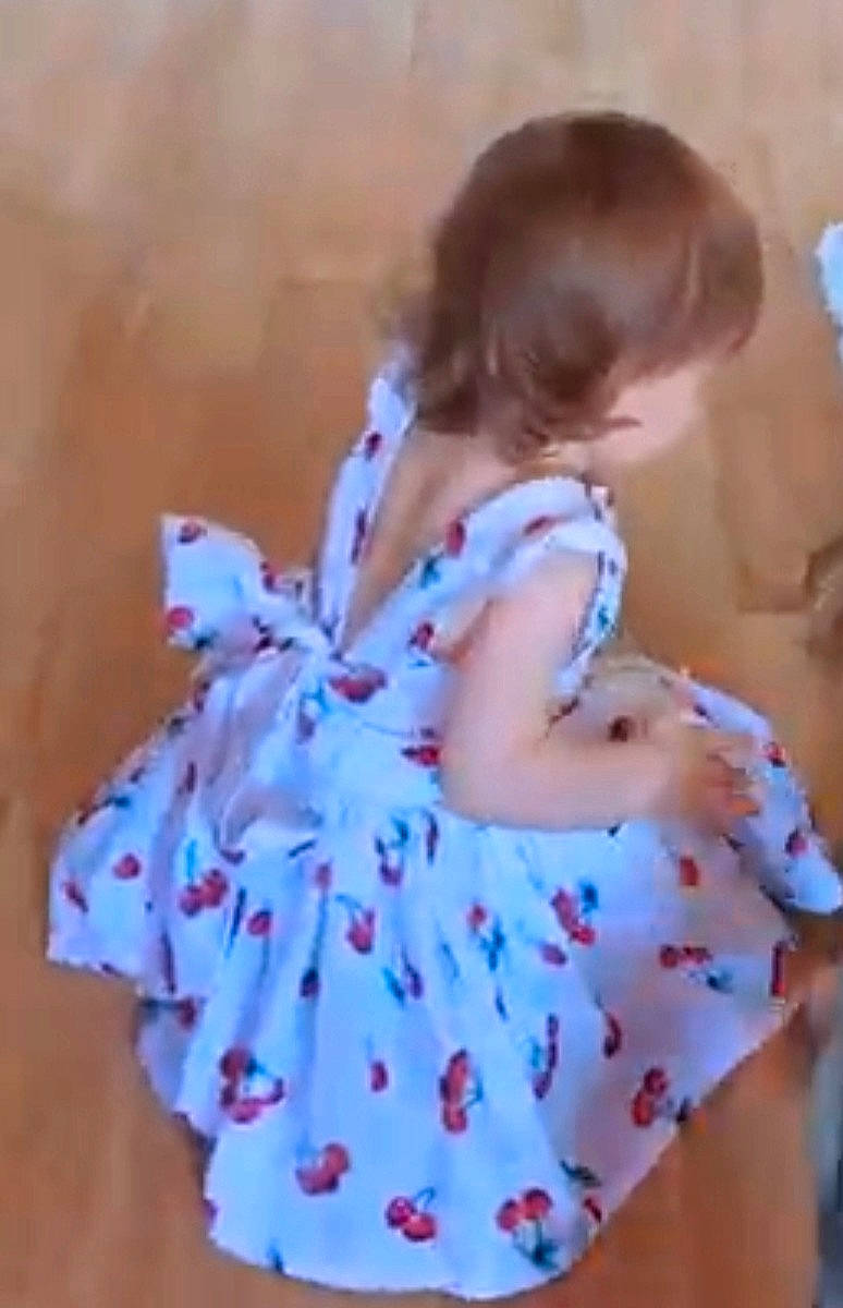 Enora a rejoint le concours — aidez-le/la à gagner de superbes lots ! baby_toddler_clothing, brown_hair, child, day_dress, dress, electric_blue, fashion_design, happy, human_leg, neck, one_piece_garment, pattern, peach, person, petal, sleeve, thigh, toddler, toy, vintage_clothing