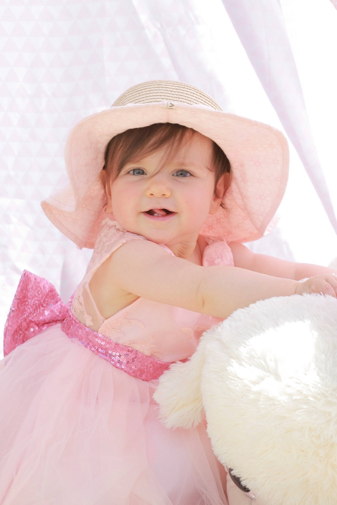 Léona participe au concours pour gagner de l'argent avec cette photo : baby, baby_toddler_clothing, beauty, bridal_accessory, bridal_clothing, dress, embellishment, event, flash_photography, gown, happy, headpiece, mythical_creature, person, petal, pink, skin, smile, textile, toddler