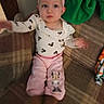 baby, child, infant, sitting, couch, portrait, headband, bow, pink_clothing, mickey_mouse, patterned_outfit, wide_eyes, indoors, furniture, living_room, textile, arm_raised, toys, flash_photography, adorable