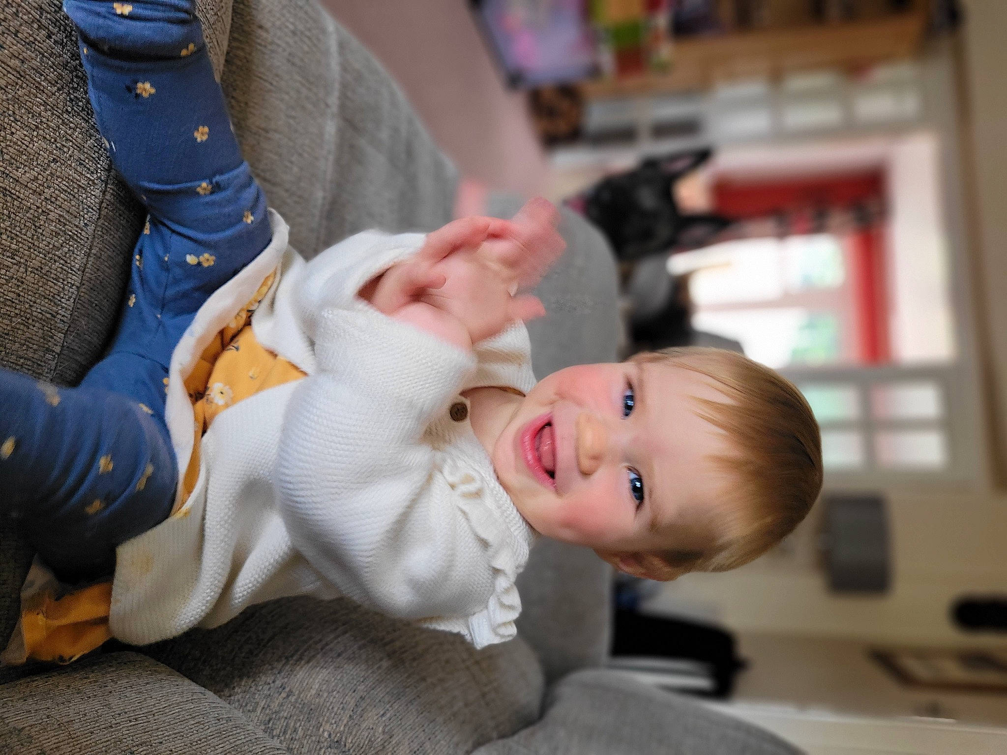 Kaitlyn is registered to the contest to win money with this photo: baby, baby_toddler_clothing, child, clothing, comfort, dress, elbow, face, finger, foot, gesture, happy, human_leg, joy, knee, person, sitting, skin, sleeve, smile