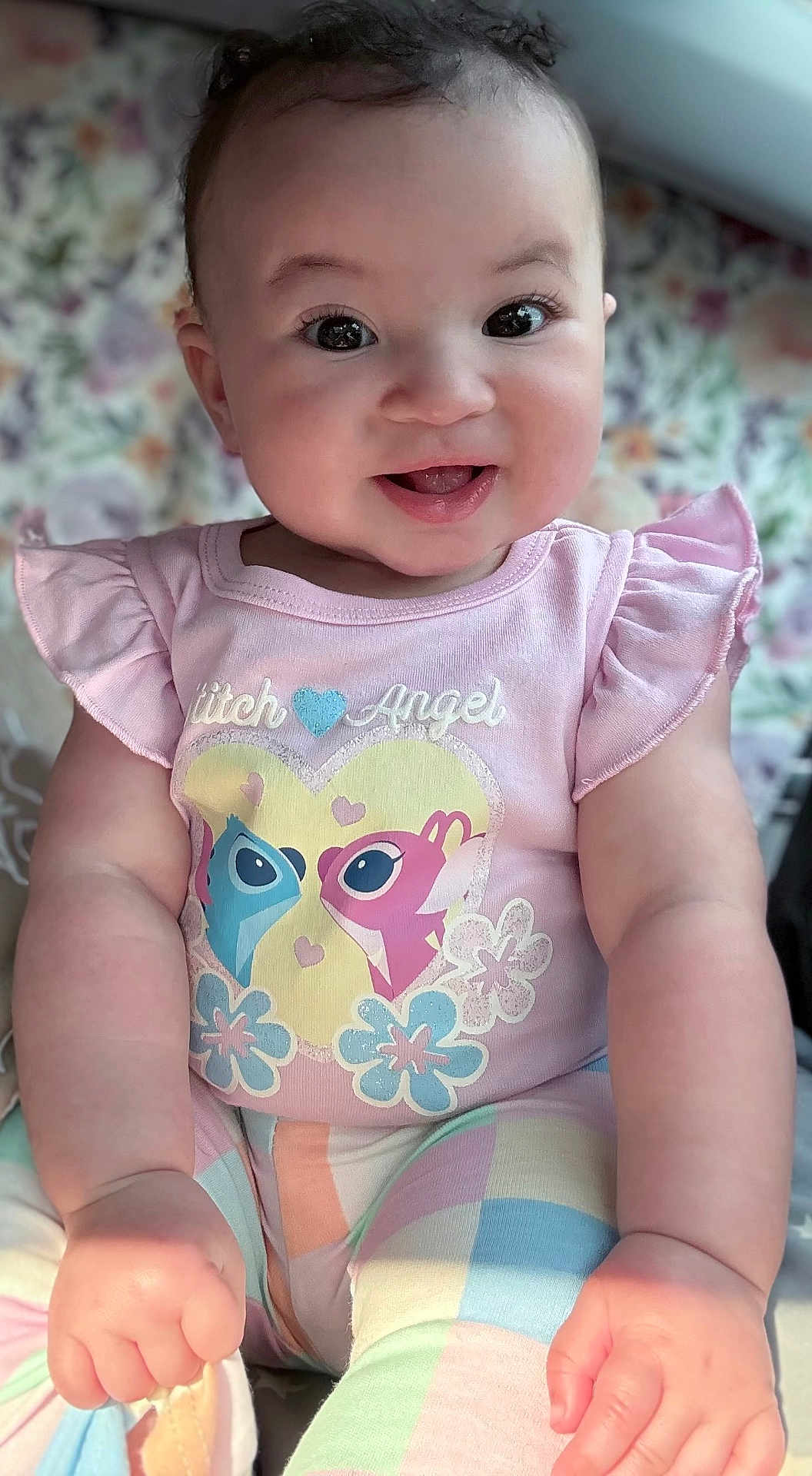 Karizmah joined the competition — help win amazing prizes! baby, child, smiling, sitting, pastel_colors, cute, portrait, clothing, patterned_pants, pink_shirt, floral_background, happy, face, arms, hands, indoor, soft_light, infant, cute_expression, young_child