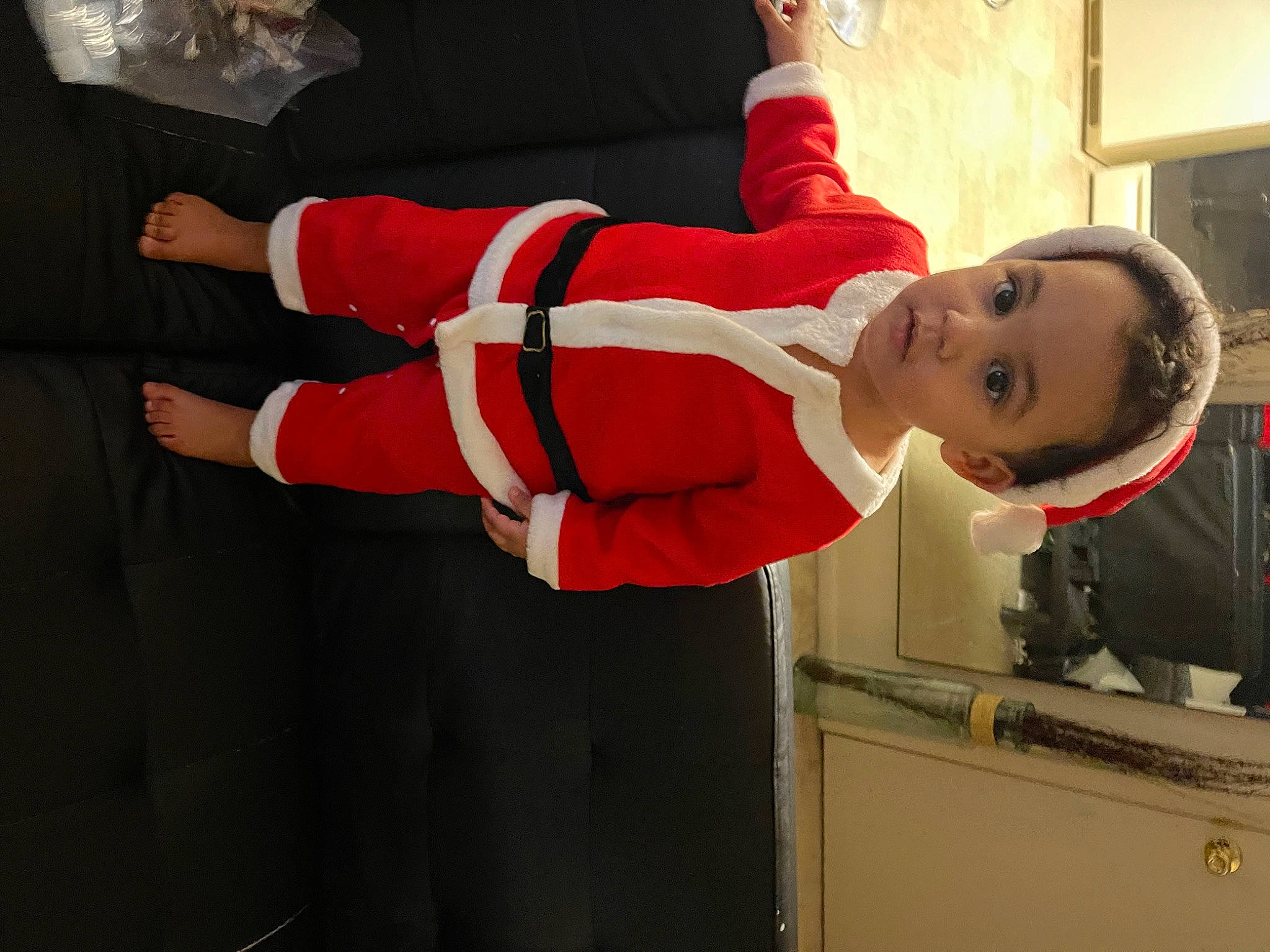 Adrian is registered to the contest to win money with this photo: baby_toddler_clothing, carmine, child, christmas, costume, elbow, event, fictional_character, fun, gesture, glove, happy, person, personal_protective_equipment, sleeve, smile, sportswear, thumb, toddler, window