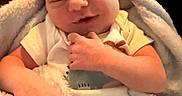 Julius is registered to the contest to win money with this photo: baby, blanket, child, clothing, cozy, cute, face, fuzzy, hand, indoor, infant, newborn, person, portrait, skin, smile, soft, warm, wrapped, young