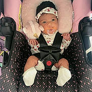 Amy Salome joined the competition — help win amazing prizes! baby, infant, child, car_seat, harness, pacifier, headband, floral_clothing, pink, plush_toy, sitting, portrait, wide_eyes, indoors, vehicle, safety, blanket, cushion, baby_clothing, photography