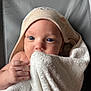 baby, towel, hood, blue_eyes, close_up, face, skin, hand, infant, cute, soft, blanket, texture, cozy, portrait, looking, wrapped, child, newborn, indoor