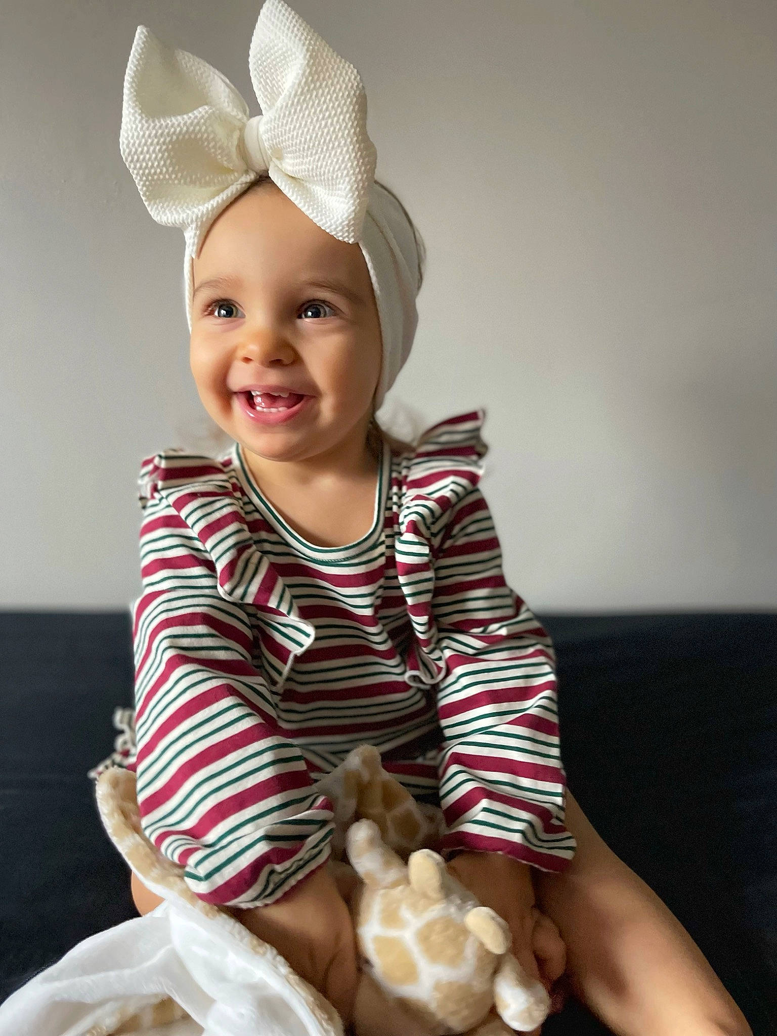 Quinn is registered to the contest to win money with this photo: baby, baby_toddler_clothing, cap, child, companion_dog, costume_hat, face, fashion_accessory, flash_photography, fun, happy, headwear, human_leg, joy, knee, person, sitting, sleeve, smile, stuffed_toy