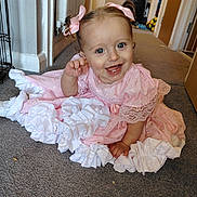 Lila-Rose is registered to the contest to win money with this photo: baby, child, girl, pink_dress, ruffles, smiling, happy, carpet, indoor, home, hair_bows, pigtails, person, cute, infant, floor, hand_raised, blue_eyes, portrait, candid