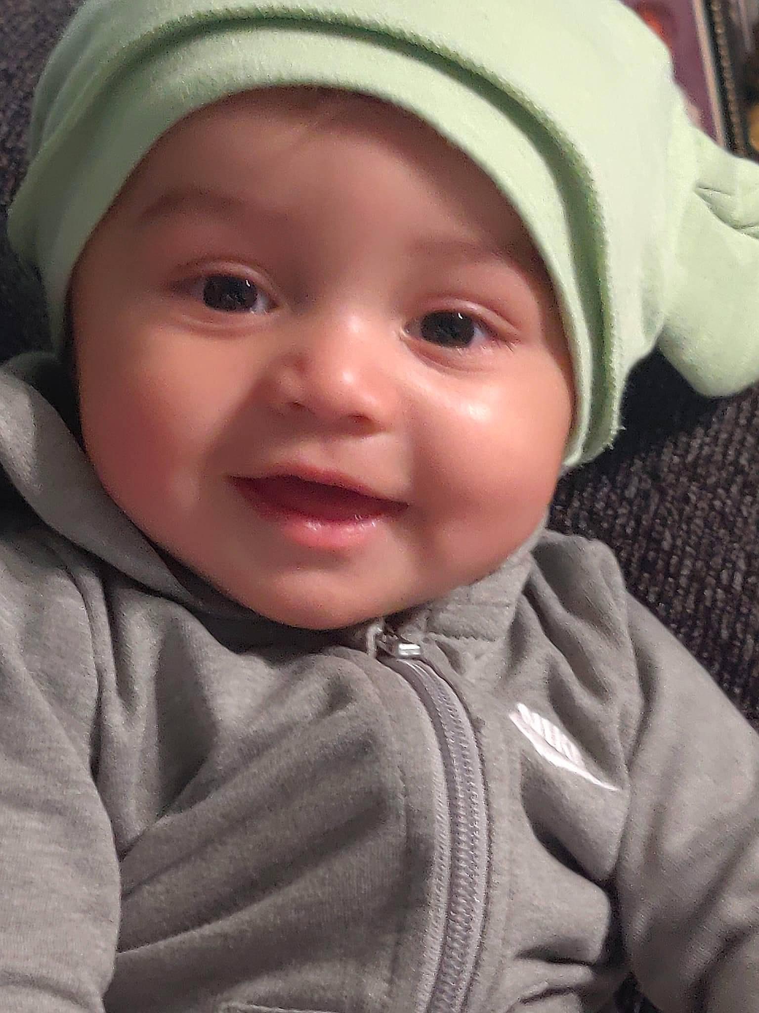 Jaxx is registered to the contest to win money with this photo: baby, cap, cheek, eye, eyebrow, face, facial_expression, happy, headgear, headwear, iris, lip, mouth, nose, organ, outerwear, person, photograph, skin, sleeve