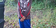 Bryce joined the competition — help win amazing prizes! child, forest, outdoor, leaves, trees, nature, person, standing, clothing, long_hair, shoes, car_door, casual, blue_pants, patterned_shirt, greenery, daylight, young, smile, adventure