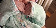 Emiley joined the competition — help win amazing prizes! newborn, baby, sleeping, blanket, knit_hat, hand, person, adult_hand, wristband, cozy, indoor, soft, cute, infant, closeup, wearing, pattern, floral, peaceful, resting