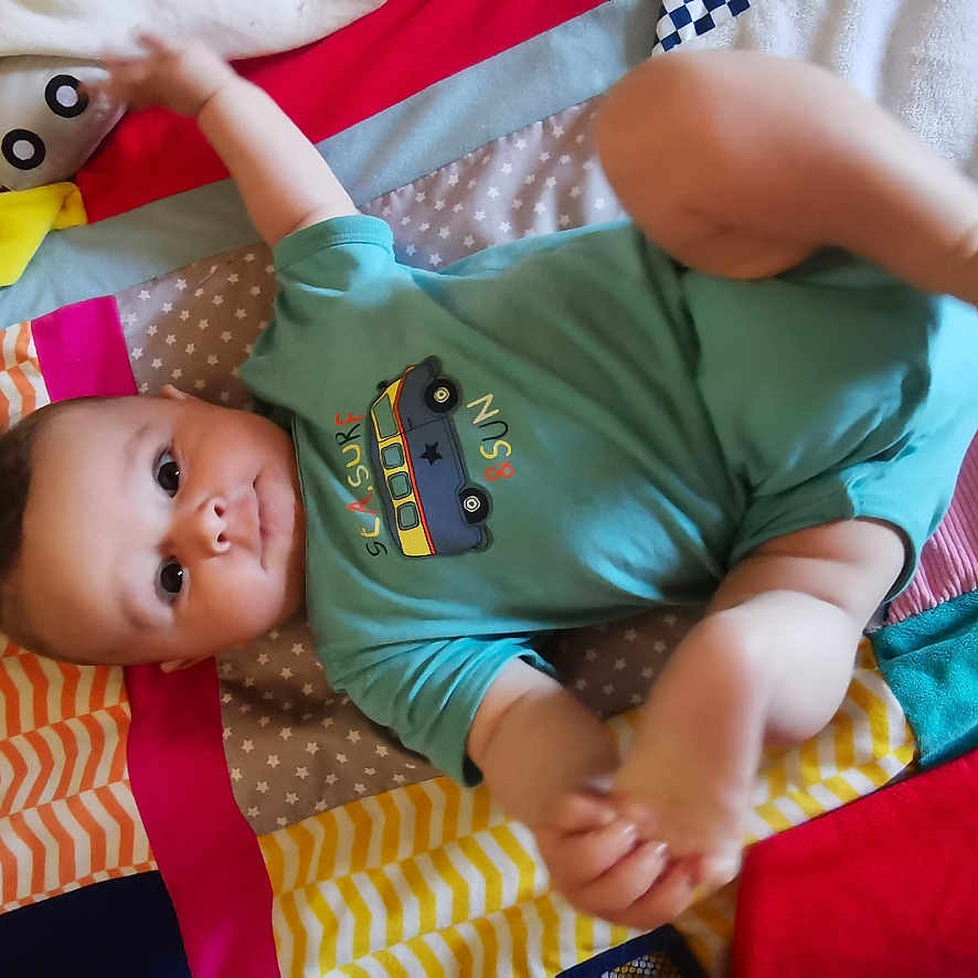 Paco a rejoint le concours — aidez-le/la à gagner de superbes lots ! baby, baby_toys, blanket, child, clothing, colorful, cute, face, floor, infant, laying, onesie, pattern, playful, portrait, red, soft, star_pattern, striped, texture