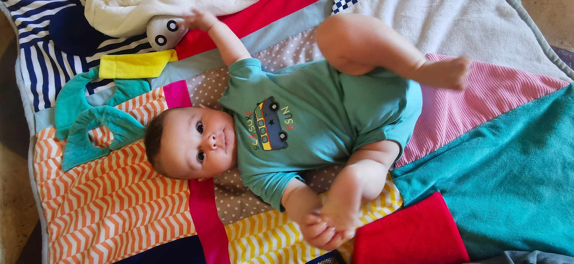 Paco a rejoint le concours — aidez-le/la à gagner de superbes lots ! baby, child, infant, blanket, colorful, onesie, clothing, pattern, playful, cute, face, portrait, laying, floor, soft, texture, baby_toys, striped, star_pattern, red