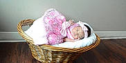 Makayla is registered to the contest to win money with this photo: baby, basket, blanket, child, cozy, cute, decor, floor, headband, indoor, infant, newborn, peaceful, pink_dress, portrait, resting, sleeping, soft, wicker, wooden_floor