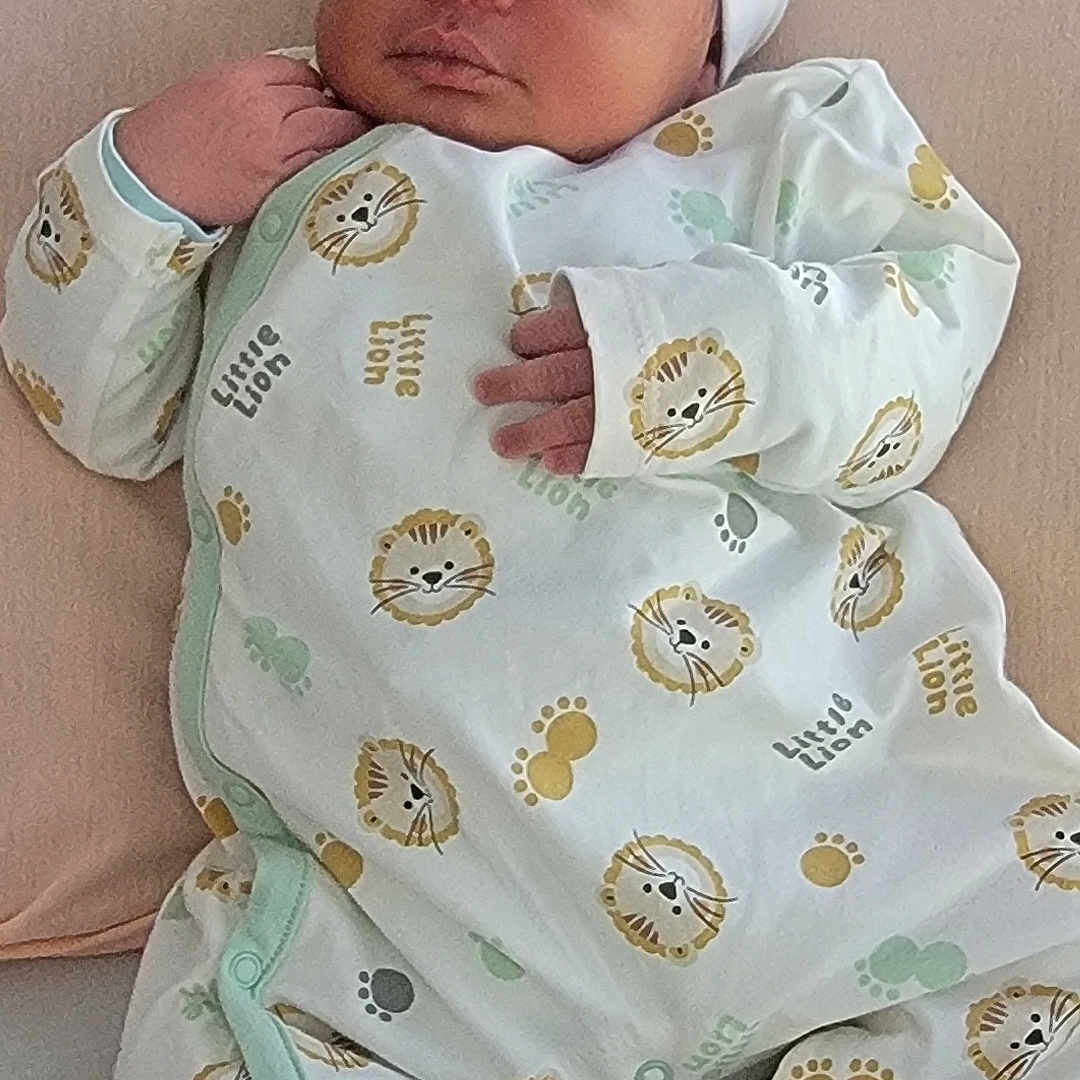 Jassy participe au concours pour gagner de l'argent avec cette photo : baby, child, clothing, cozy, cute, footwear, hat, human, indoors, infant, lion, newborn, onesie, pastel_colors, pattern, peaceful, portrait, sleep, sleeping, soft_surface