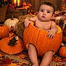 baby, child, pumpkin, autumn, fall, maple_leaves, orange, portrait, sitting, indoor, seasonal, halloween, candle, lantern, rustic, blanket, wooden_floor, decor, infant, smiling