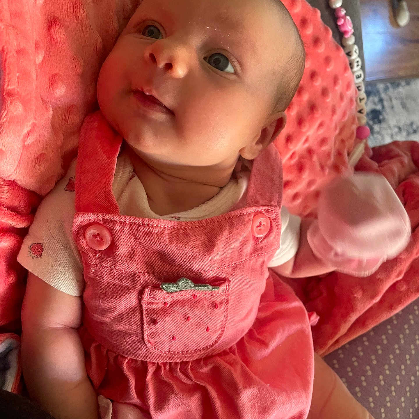 Athena is registered to the contest to win money with this photo: baby, bonnet, cap, clothing, coat, cushion, dress, face, happy, hat, head, homedecor, hood, jacket, pants, person, photography, portrait, sitting, smile