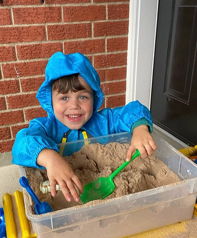 Kayden joined the competition — help win amazing prizes! baby_toddler_clothing, brick, brickwork, child, door, fun, grass, hat, headwear, hoodie, jacket, joy, leisure, person, play, recreation, sitting, smile, soil, stuffed_toy