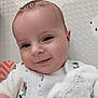 baby, smile, face, close_up, plush_toy, white_clothing, patterned_background, cute, infant, child, happy, indoors, soft_toy, portrait, young_child, head, cheeks, eyes, skin, baby_boy