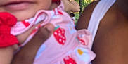 Jasmine is registered to the contest to win money with this photo: baby, child, smiling, hat, strawberry_pattern, pink_clothing, adult_hand, outdoor, canopy_tent, trees, shoulder, arm, person, face, close_up, summer, daylight, nature, holding, cute