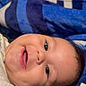 baby, smiling, face, infant, blanket, blue, cozy, happy, cute, child, portrait, lying_down, skin, expression, young, person, indoors, closeup, head, warm