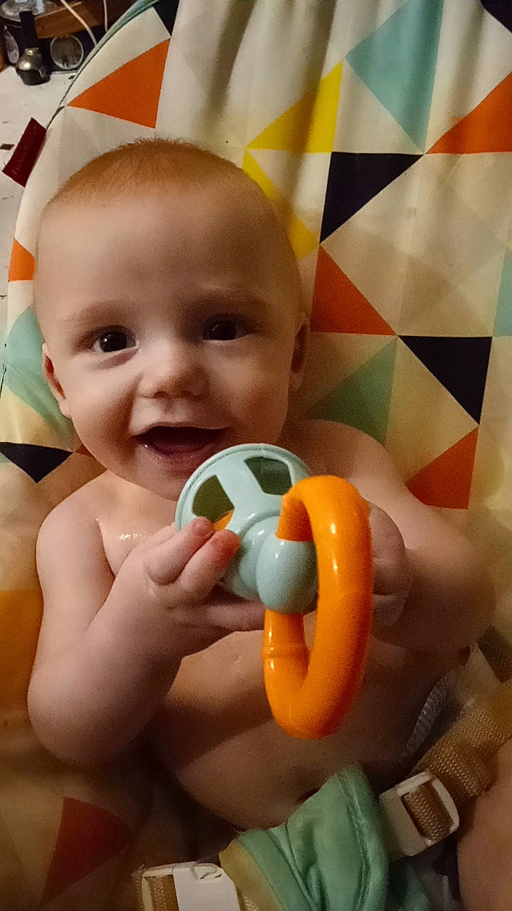 Braxtyn is registered to the contest to win money with this photo: arm, baby, baby_playing_with_toys, cheek, ear, eye, eyebrow, eyelash, hairstyle, hand, human_body, iris, joy, lip, mouth, nose, organ, person, photograph, skin