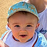Mahëlo a rejoint le concours — aidez-le/la à gagner de superbes lots ! baby, child, smiling, face, cap, bib, blue_clothing, person, portrait, closeup, happy, outdoor, sunlight, headwear, infant, cute, skin, eyes, mouth, toddler
