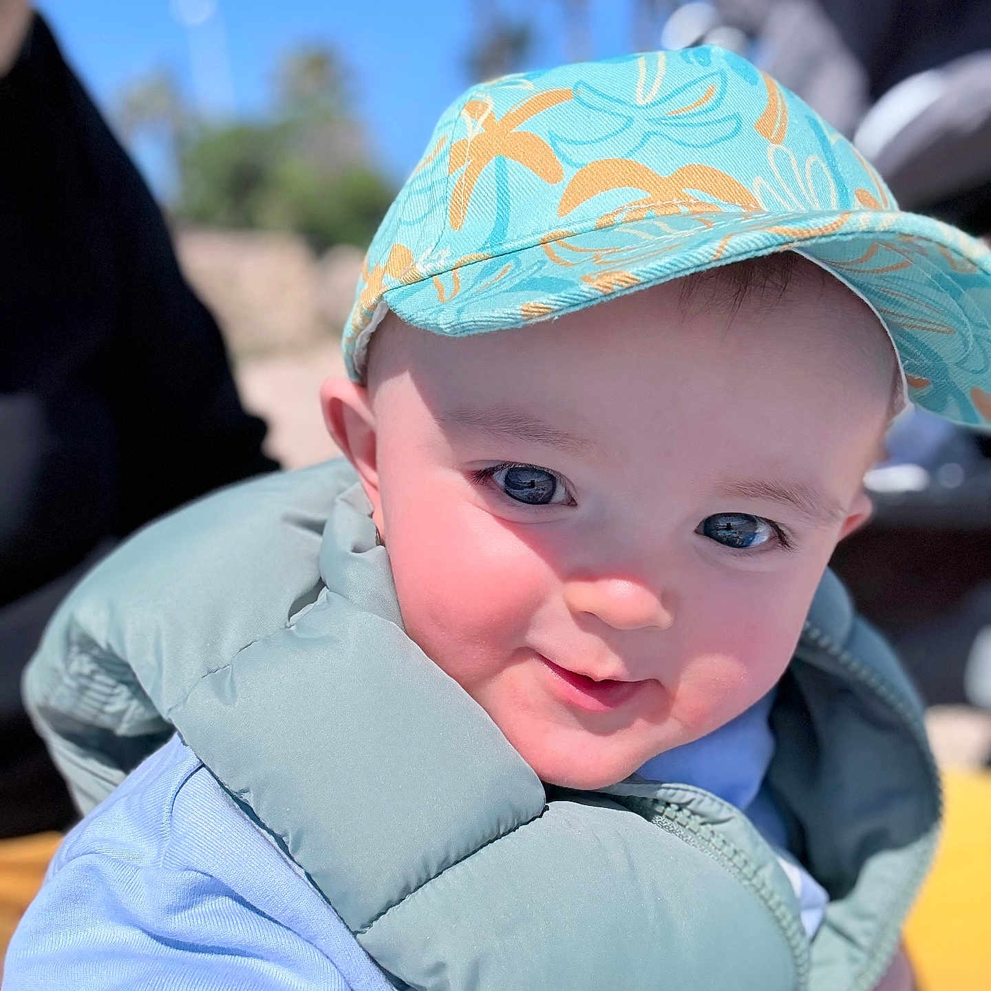 Mahëlo participe au concours pour gagner de l'argent avec cette photo : baby, child, smiling, cap, hat, blue_sky, outdoor, vest, puffy_jacket, close_up, face, happy, sunlight, cute, person, portrait, daylight, casual_clothing, headwear, infant
