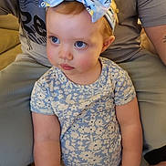 Kloe joined the competition — help win amazing prizes! toddler, child, blue_eyes, headband, bow, floral_pattern, shirt, person, indoor, seated_adult, legs, skin, curly_hair, short_sleeve, candid, soft_lighting, portrait, cute, expression, baby