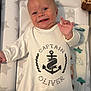 Oliver joined the competition — help win amazing prizes! baby, infant, smiling, onesie, white_clothing, anchor_design, text_on_clothing, padded_surface, star_pattern, hand, face, blue_eyes, happy, cute, indoor, blanket, toy, giraffe, child, portrait