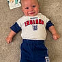 baby, child, smile, carpet, clothing, tshirt, shorts, england, milestone_card, giraffe, portrait, infant, happy, person, young_child, indoor, cute, lying_down, four_months_old, celebration