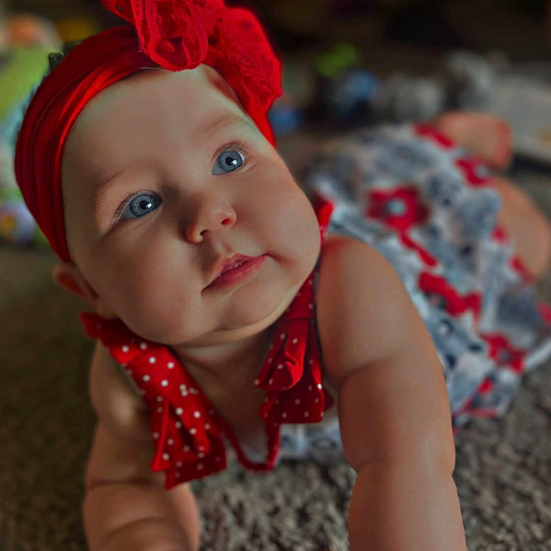 Eliana joined the competition — help win amazing prizes! adorable, baby, blue_eyes, carpet, child, chubby_cheeks, clothing, crawling, cute, expression, face, hand, headwear, indoor, infant, person, portrait, red_bow, red_dress, skin