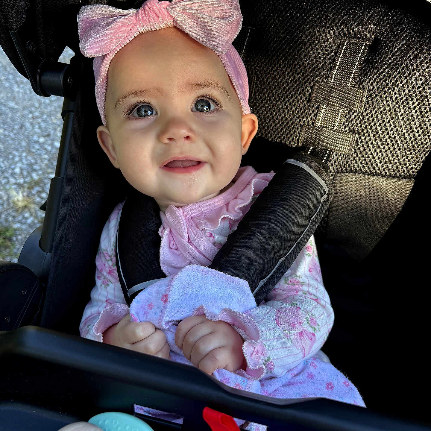 Brynlee is registered to the contest to win money with this photo: baby, child, infant, stroller, portrait, smiling, happy, pink_bow, headband, floral_outfit, blanket, toy, teether, seated, outdoor, carriage, face, eyes, hands, close_up