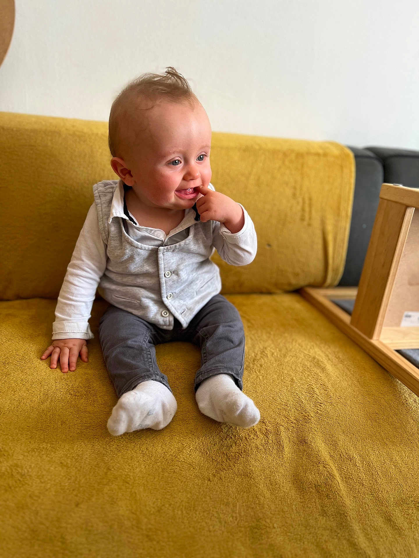 Mylan a rejoint le concours — aidez-le/la à gagner de superbes lots ! baby, child, sitting, couch, yellow_couch, clothing, socks, vest, long_sleeve_shirt, indoor, furniture, person, cute, infant, portrait, hand, face, expression, curious, wooden_frame