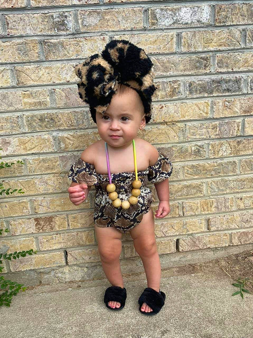 Tatiana is registered to the contest to win money with this photo: baby_toddler_clothing, brick, brickwork, child, door, eye, face, fashion_accessory, flash_photography, grass, hair, happy, head, headpiece, jewellery, magenta, pattern, people_in_nature, person, toddler