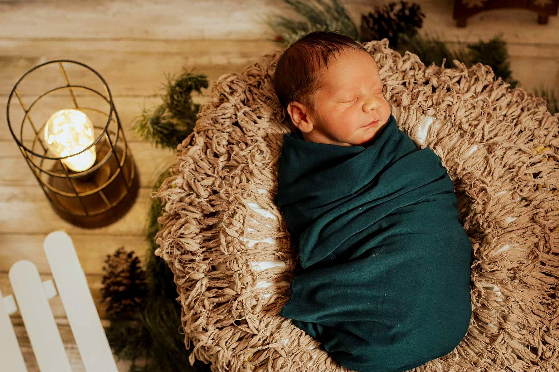 Danny is registered to the contest to win money with this photo: candle, candle_holder, child, comfort, conifer, event, fun, fur, grass, happy, outerwear, people_in_nature, person, room, sitting, toddler, tradition, tree, winter, wood